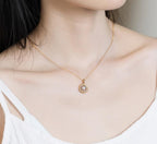 Origsoul freshwater pearl necklace with gold chain and circular pendant worn on model's neck