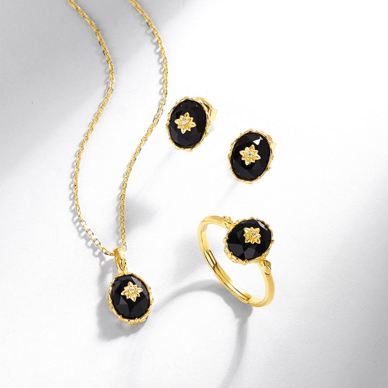 Origsoul gold jewelry set with black stones featuring a silver sterling ring, matching earrings and pendant necklace