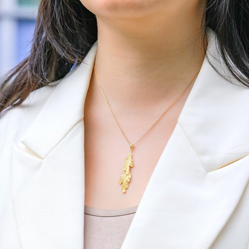 Origsoul delicate gold necklace and choker with leaf pendant worn with white blazer