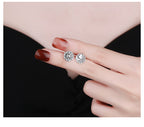 Origsoul cosmic sun and moon stud earrings in silver held by hand with dark red nails