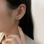 Origsoul June birth flower earrings worn on ear with delicate rose design in gold tone