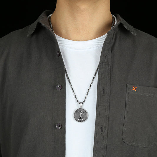 Leonardo da Vinci necklace pendant worn on a silver chain by a person in a white shirt and dark button-up shirt