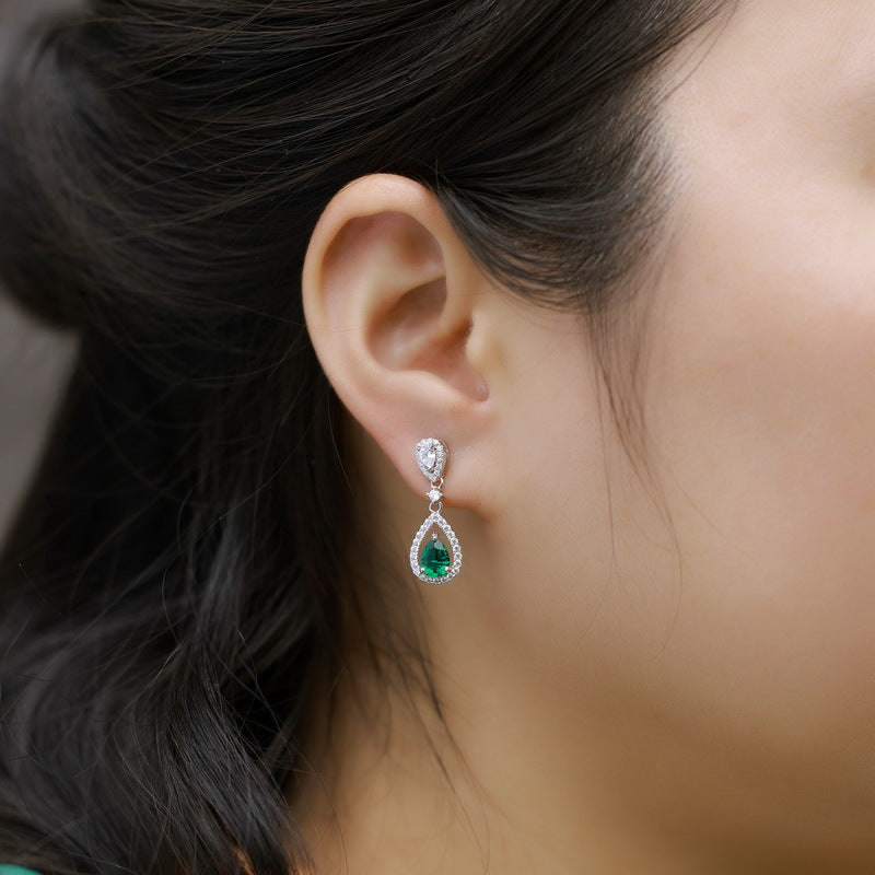 Origsoul elegant earrings with emerald teardrop gemstone and diamond accents on a woman
