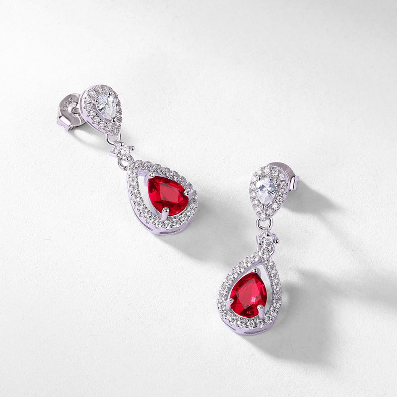 Origsoul teardrop earrings with red stones surrounded by clear crystals in silver setting