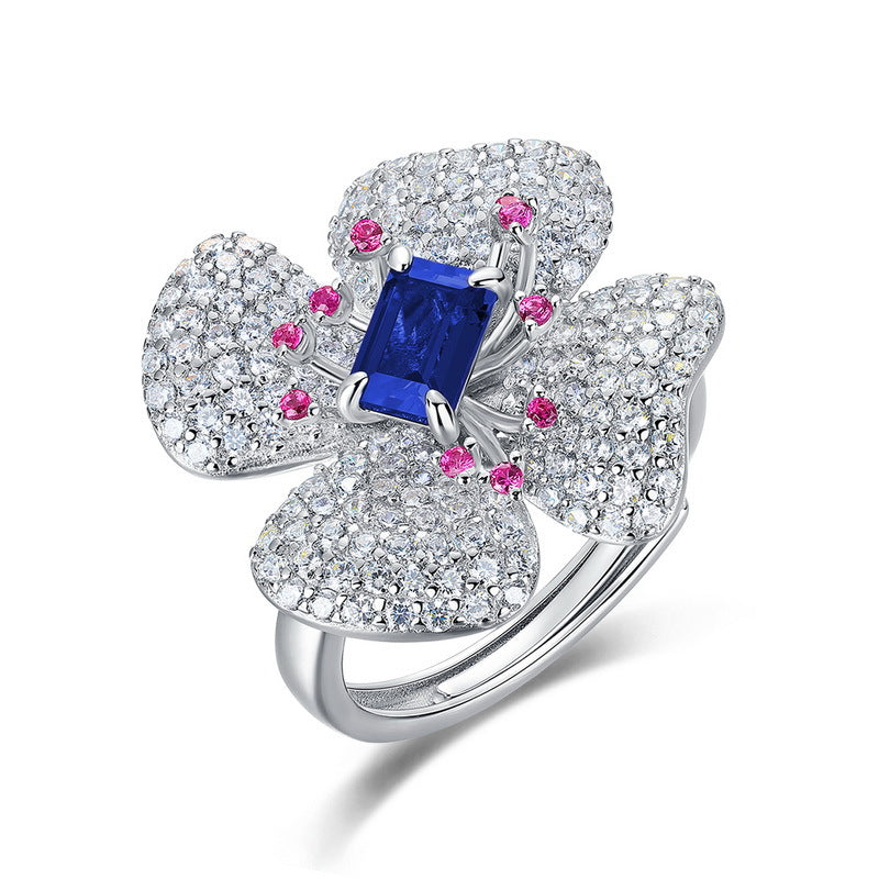 Origsoul emerald cut-engagement ring with blue center stone and floral diamond design