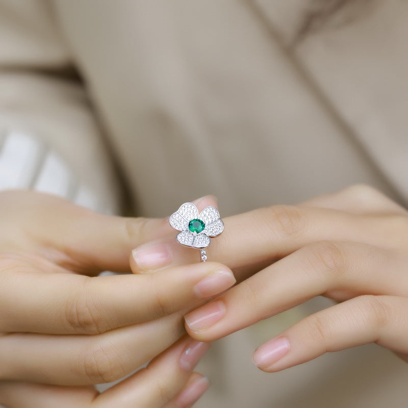 Origsoul emerald cut-engagement ring with a green gemstone and flower-inspired diamond setting