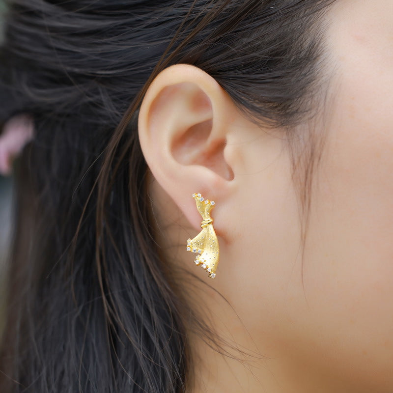 Origsoul silver sterling silver earrings worn on ear with elegant gold-tone design
