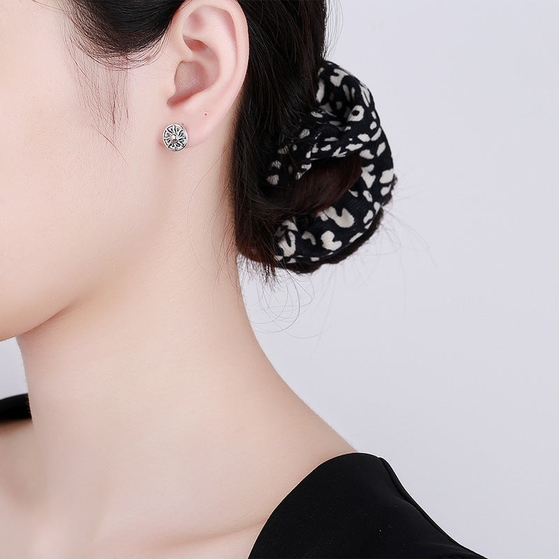 Origsoul cosmic sun and moon stud earrings worn on ear with black and white hair scrunchie