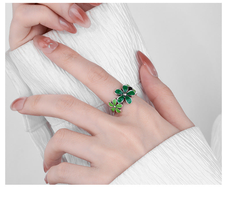 Origsoul October birth flower ring with green floral design worn on hand over white textured sleeve