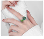 Origsoul October birth flower ring with green floral design worn on hand over white textured sleeve
