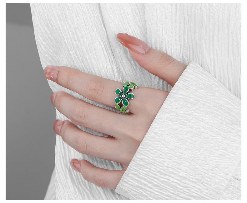 October birth flower ring by Origsoul with green floral design worn on hand with white sleeve