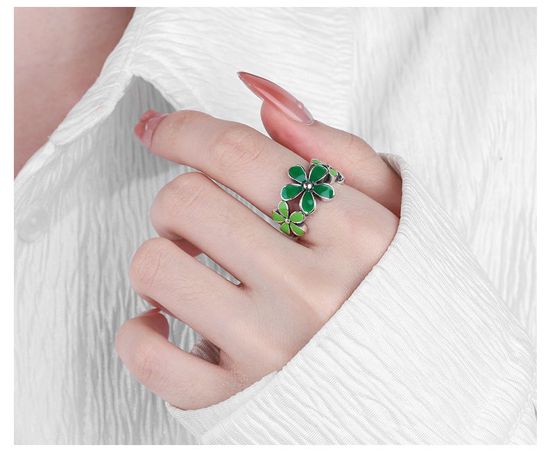Origsoul October birth flower ring with green floral design worn on hand with white textured sleeve