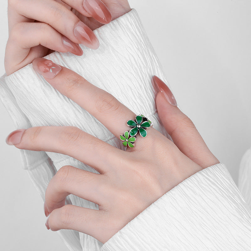 Origsoul October birth flower ring with green enamel petals worn on finger with white textured sleeve