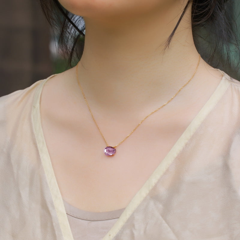 Origsoul delicate pendant in sterling silver with purple gemstone on gold chain worn on neck