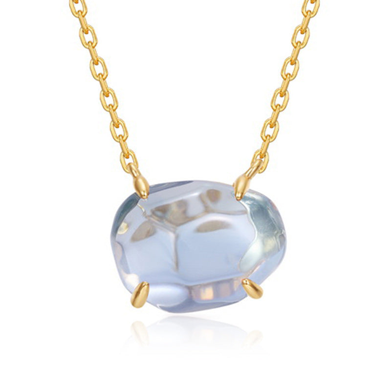 Origsoul pendant in sterling silver featuring a faceted light blue stone with gold chain