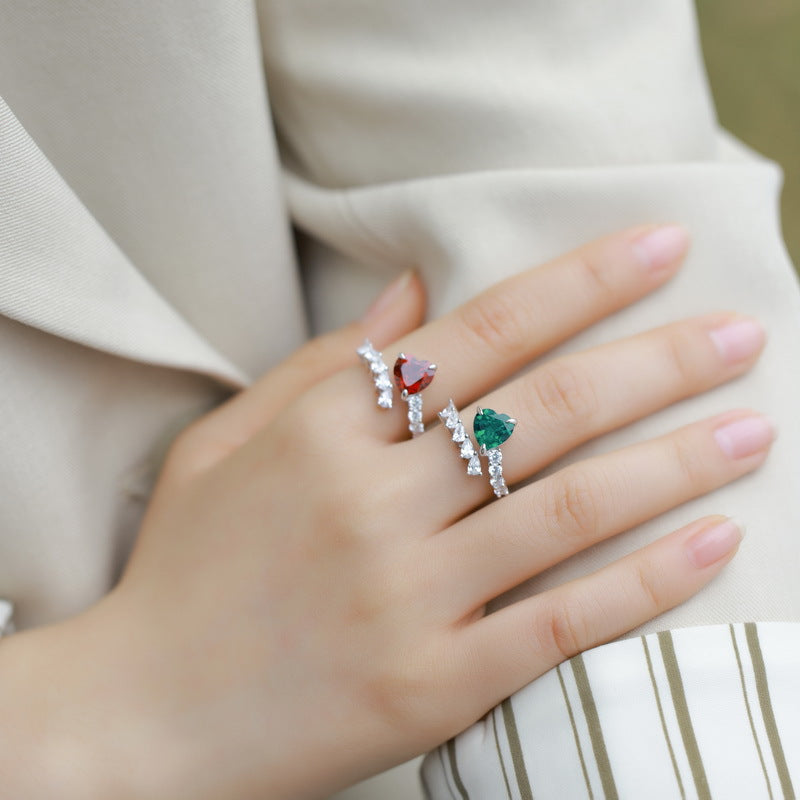 Origsoul emerald cut-engagement ring with green gemstone and diamond accents on hand