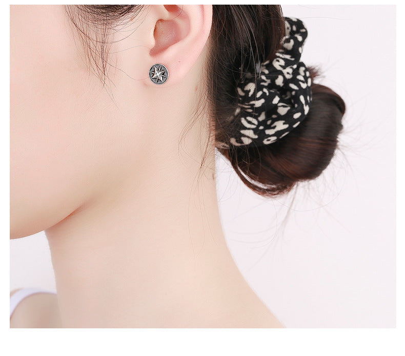 Origsoul retro black enamel earrings worn on ear with cosmic star design accessory