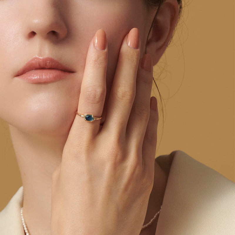 Origsoul ring sterling silver with blue gemstone worn on finger by woman with neutral nail polish