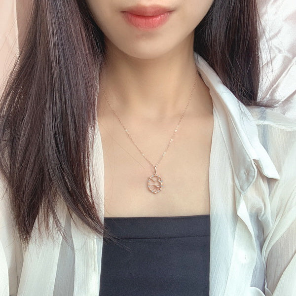 Origsoul sun moon star necklace worn on a delicate chain by a woman in a white shirt and black top