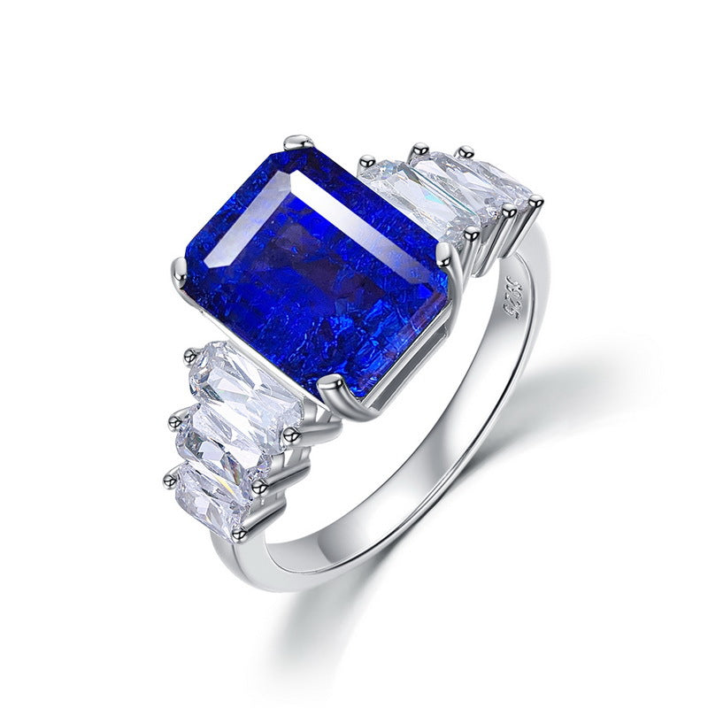 Origsoul engagement ring emerald cut with a large blue center stone and clear side stones in silver band