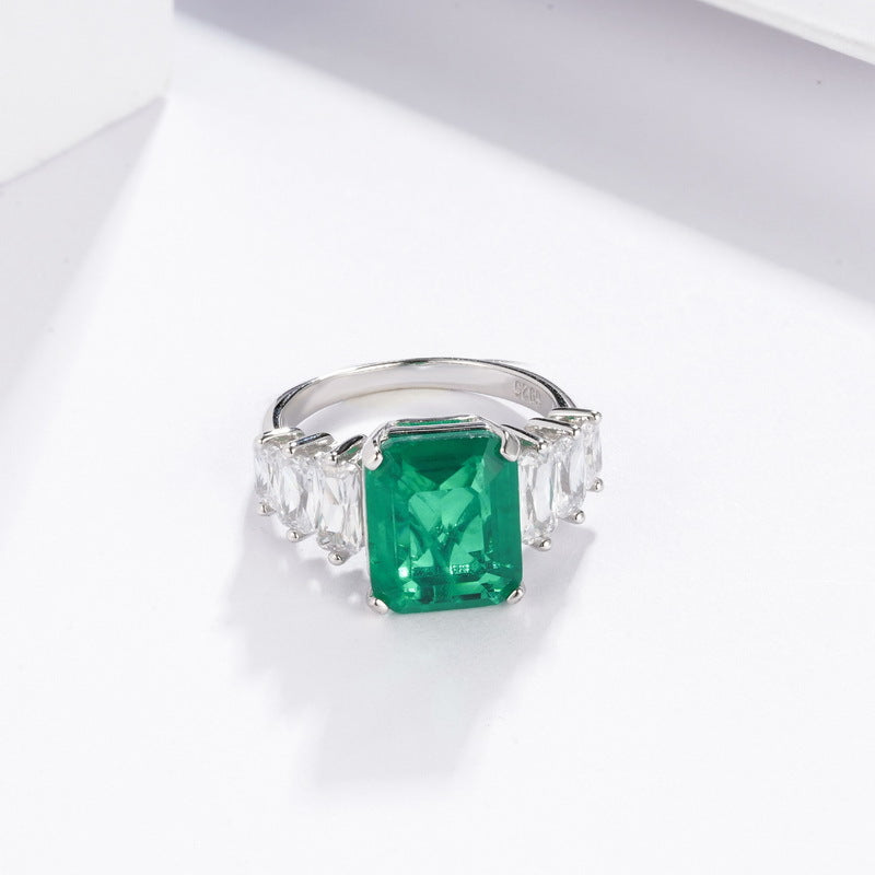 Origsoul engagement ring emerald cut featuring a vibrant green emerald center stone with clear side diamonds