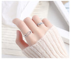 Origsoul silver safety pin ring worn on finger with another silver twisted ring and cream knit sweater
