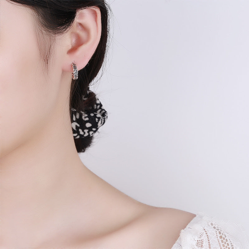Origsoul silver wheat hoop earrings worn on ear with a subtle woven design