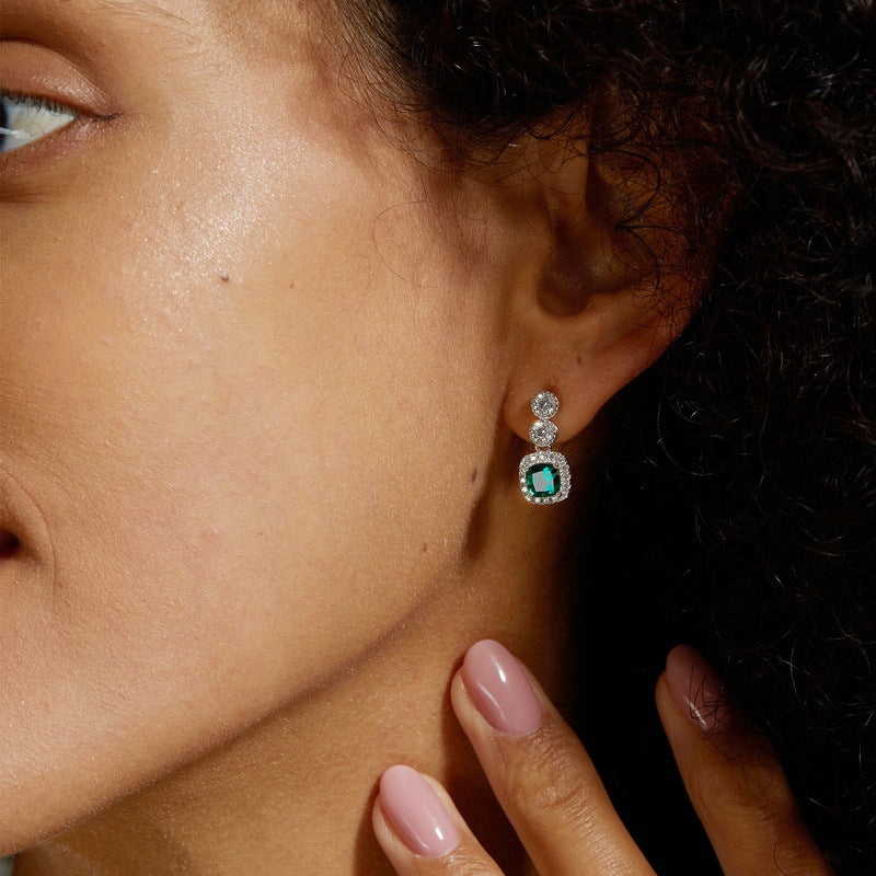 Origsoul sterling earrings silver with emerald green center stone and diamond accents on model