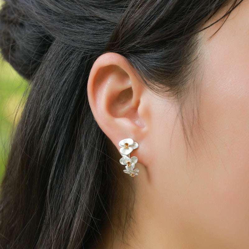 Origsoul sterling silver earrings with delicate flower design worn on ear