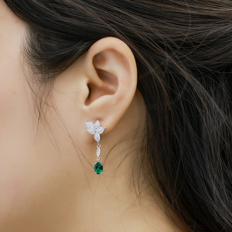 Origsoul sterling silver earrings with floral design and green gemstone drop worn on ear