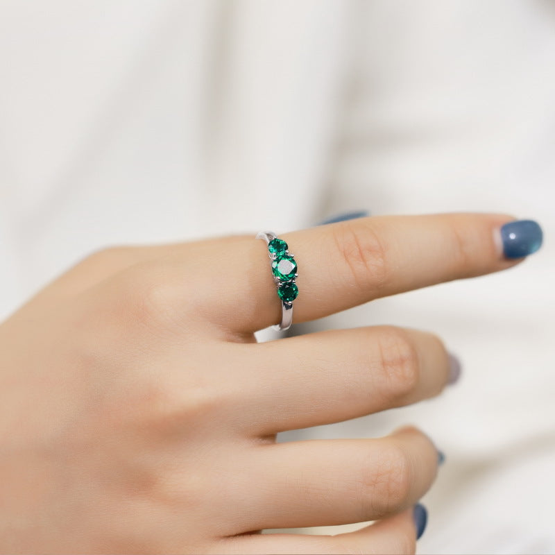 Origsoul engagement ring emerald cut with three green gemstones on silver band worn on finger