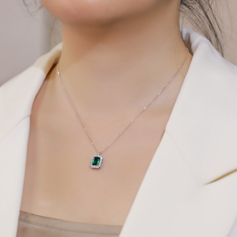 Origsoul sterling silver jelwery necklace with green gemstone pendant worn with white blazer