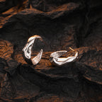 Origsoul modern bumpy hoop earrings in shiny silver displayed on textured dark background