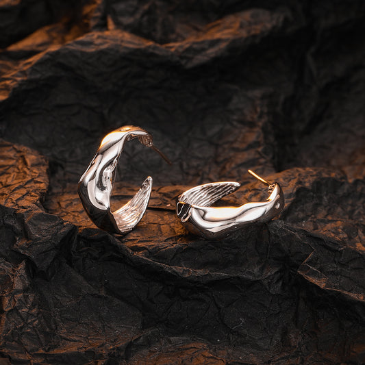 Origsoul modern bumpy hoop earrings in shiny silver displayed on textured dark background