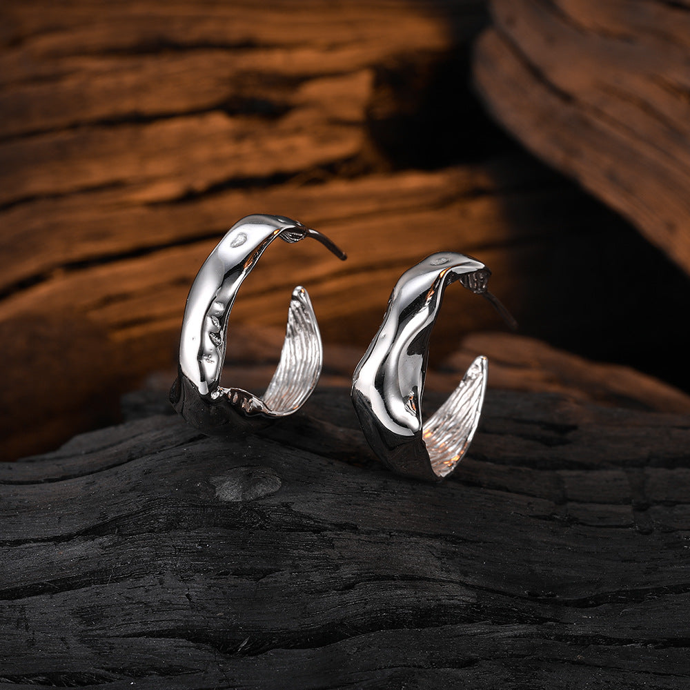 Origsoul modern bumpy hoop earrings in polished silver on rustic wood background