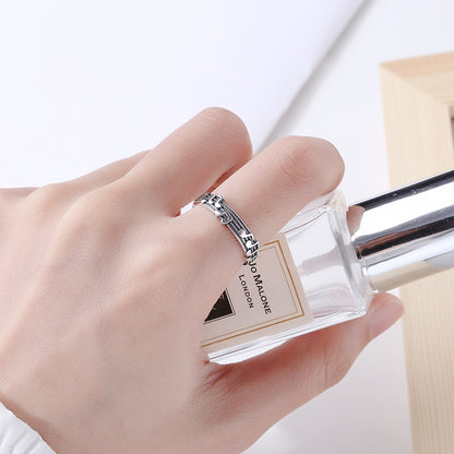 Origsoul music note eternity ring on a hand holding a perfume bottle with silver detailing