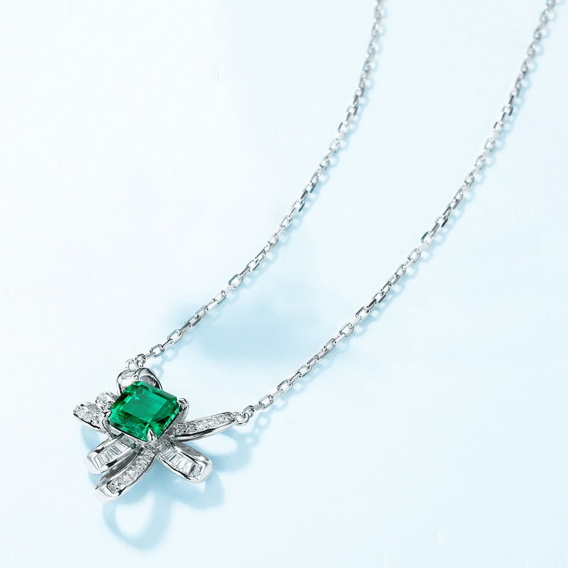 Origsoul sterling silver necklace with green gemstone and intricate bow-shaped design