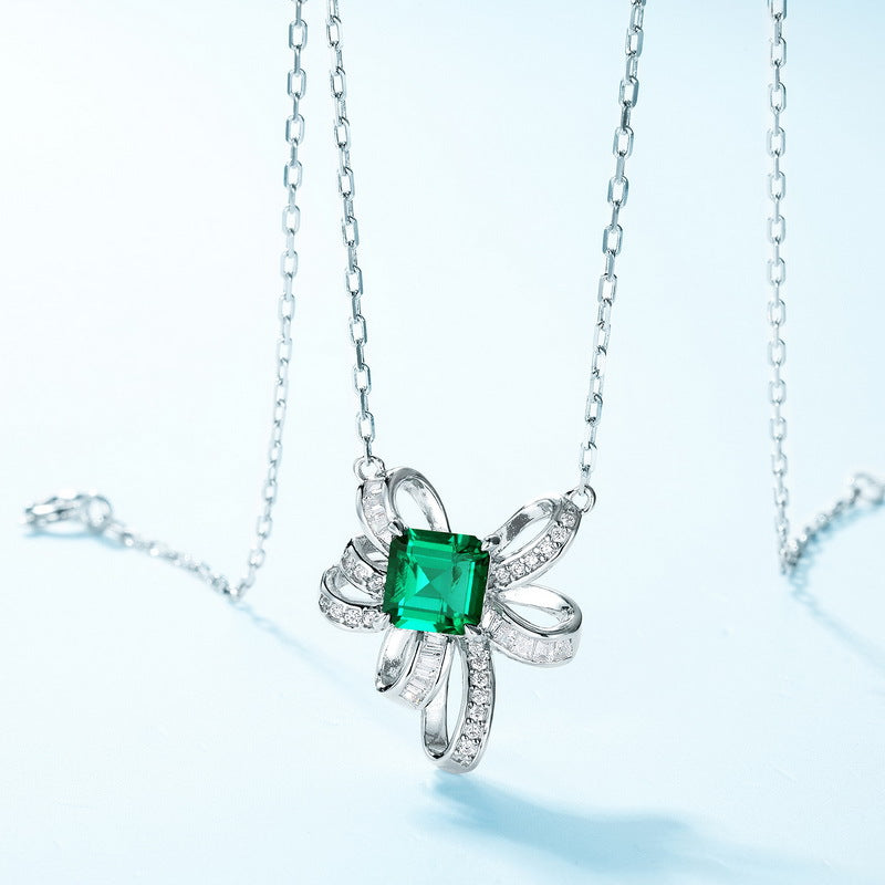 Origsoul sterling silver necklace featuring a green square gemstone and intricate ribbon design with small clear stones