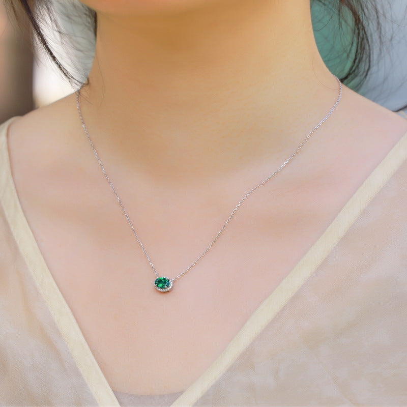 Origsoul sterling silver necklace with a small green gemstone pendant worn on a woman’s neck