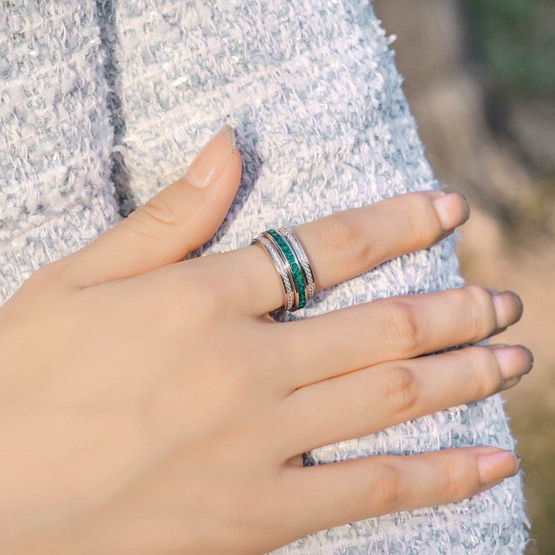 Origsoul sterling silver ring with green and black accents worn on a hand with a textured gray sleeve