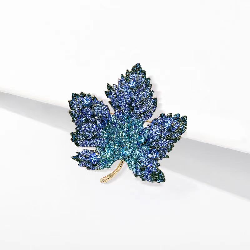 Origsoul brooch shaped like a toronto maple leaf with blue and green sparkling crystals