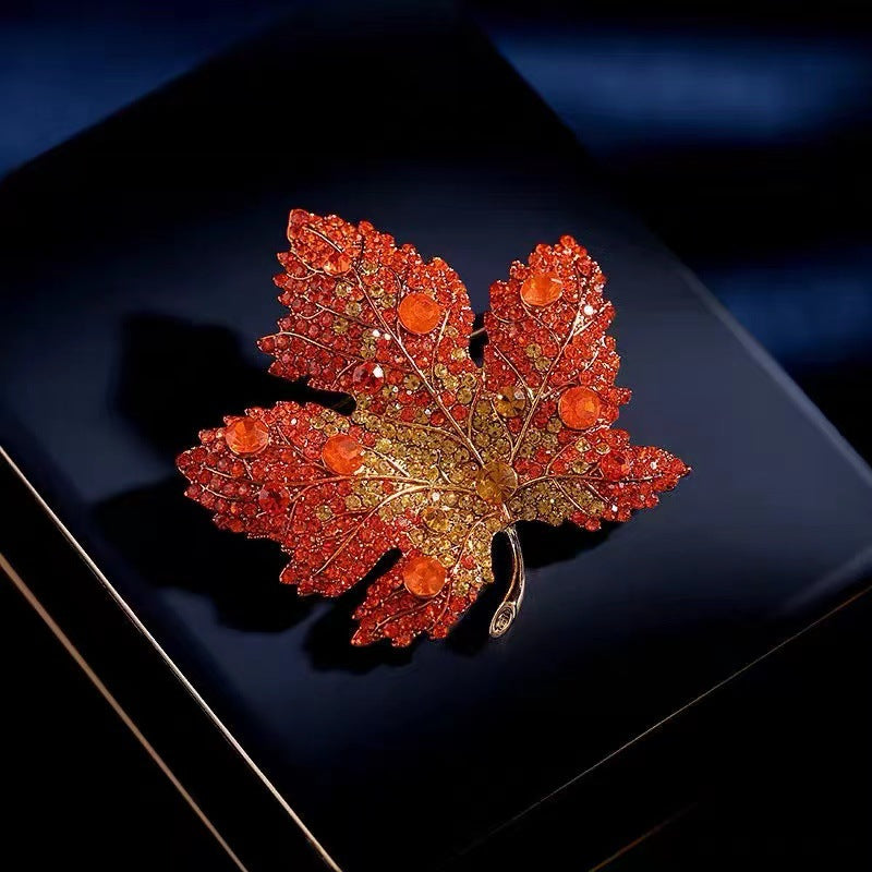 Origsoul brooch shaped like a toronto maple leaf with red and orange crystals