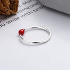 Origsoul unique minimalist silver ring with a small red bead detail on white surface