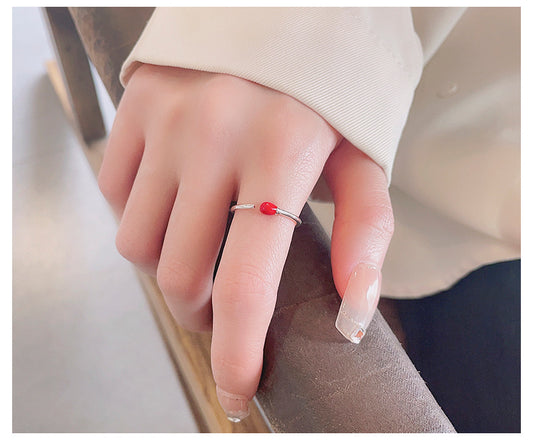Origsoul unique minimalist silver ring with a small red bead worn on a hand with neutral nail polish