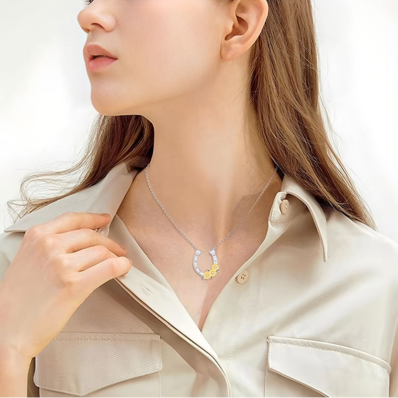 Origsoul lucky horseshoe necklace with flower detail worn by woman in beige shirt